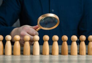 A man studies people through a magnifying glass.
