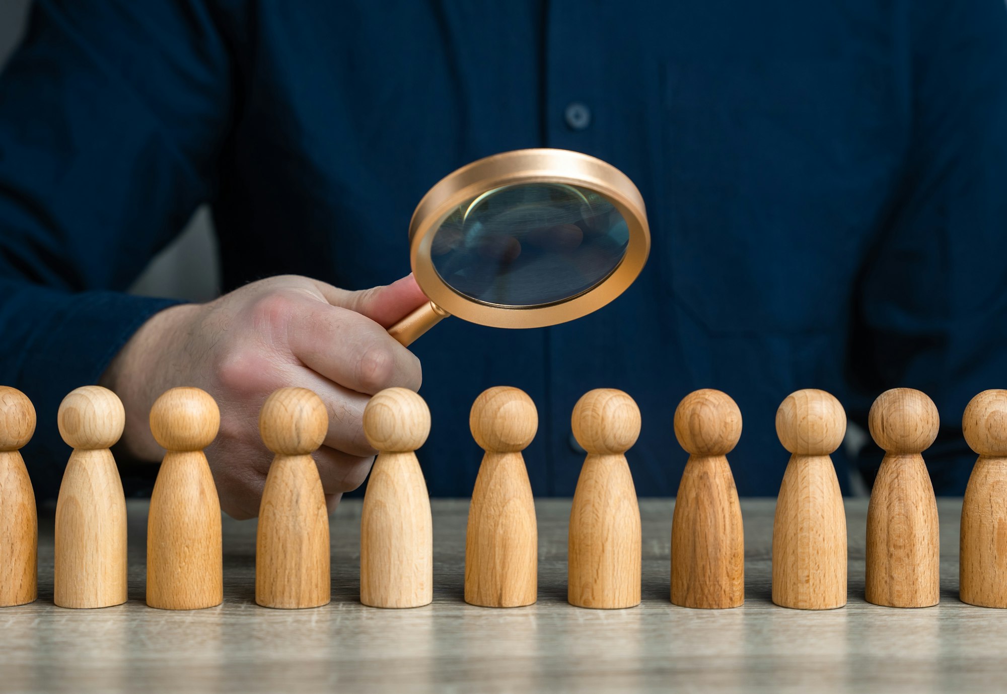 A man studies people through a magnifying glass.